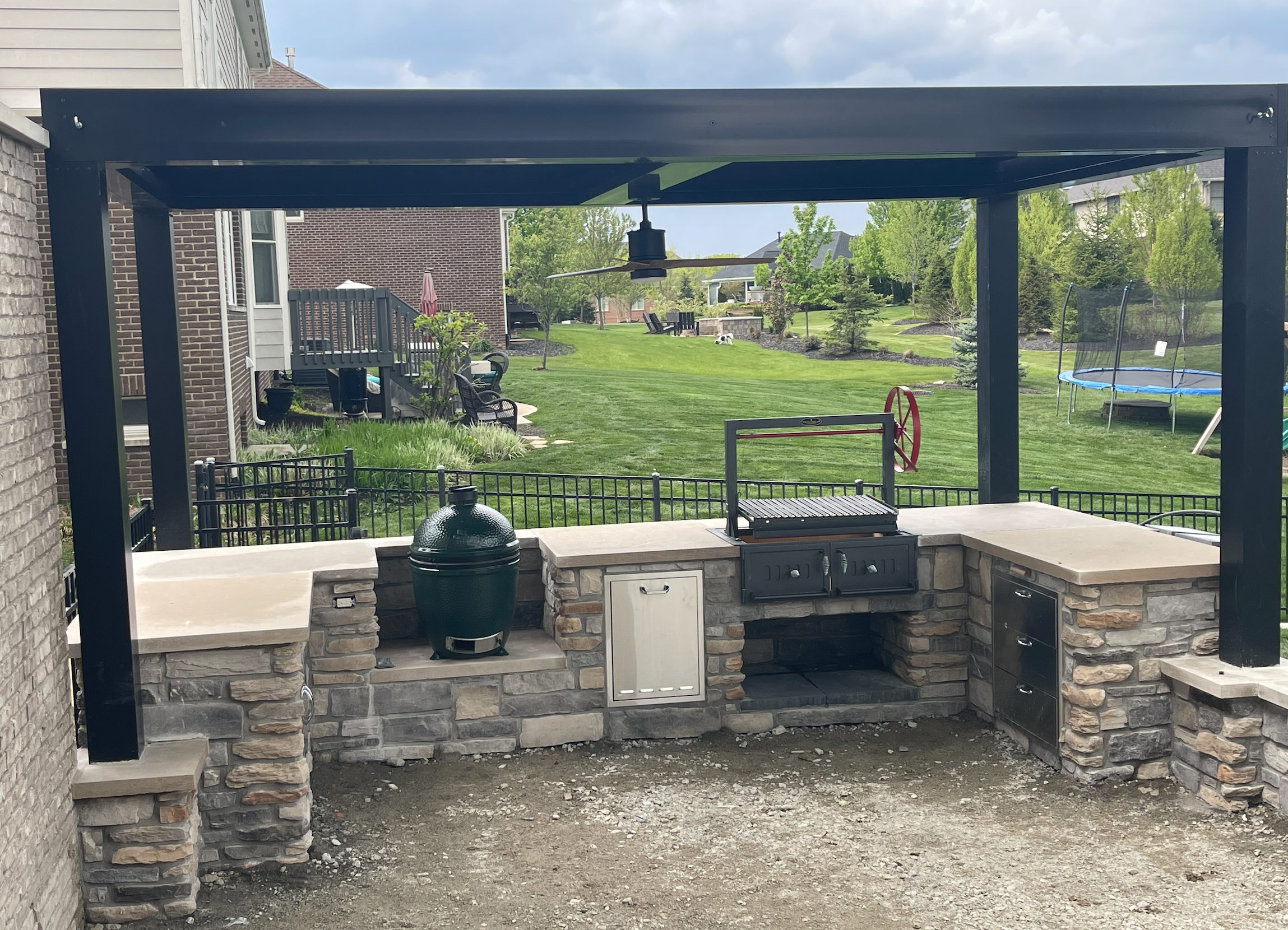 louvered roof provides protection over outdoor kitchen