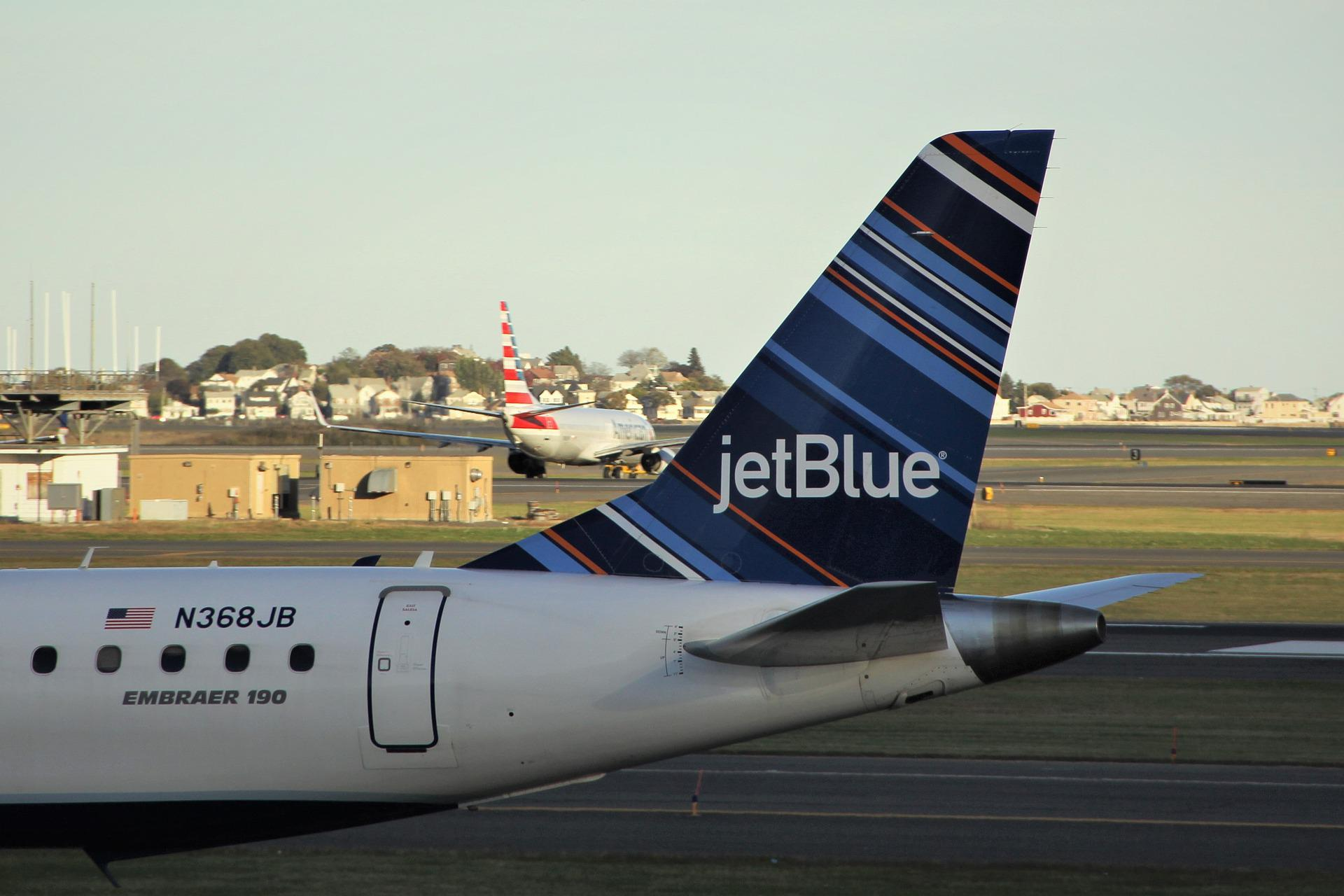 jetBlue Embraer 190 stationed at an airport tarmac.