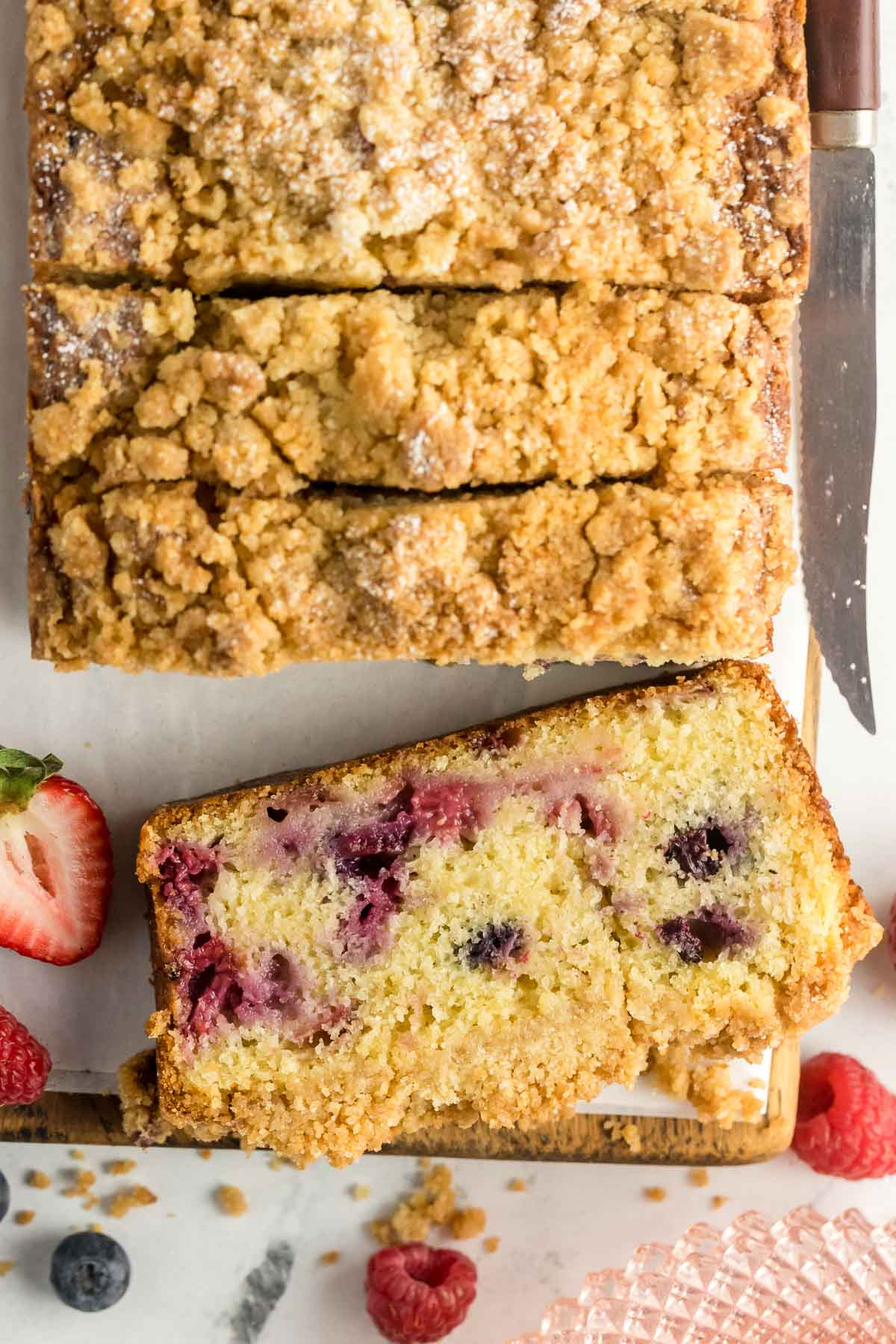 sliced berry loaf cake on a cuttin gboard