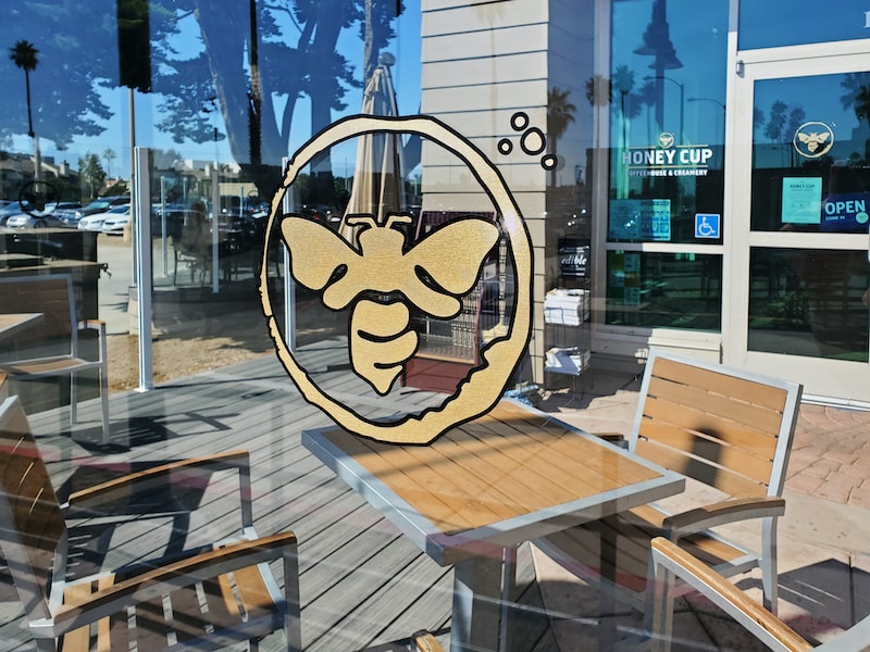 Custom window graphics for Honey Cup Coffeehouse & Creamery in the Channel Islands Harbor add a warm, inviting touch while showcasing the brand’s playful personality.