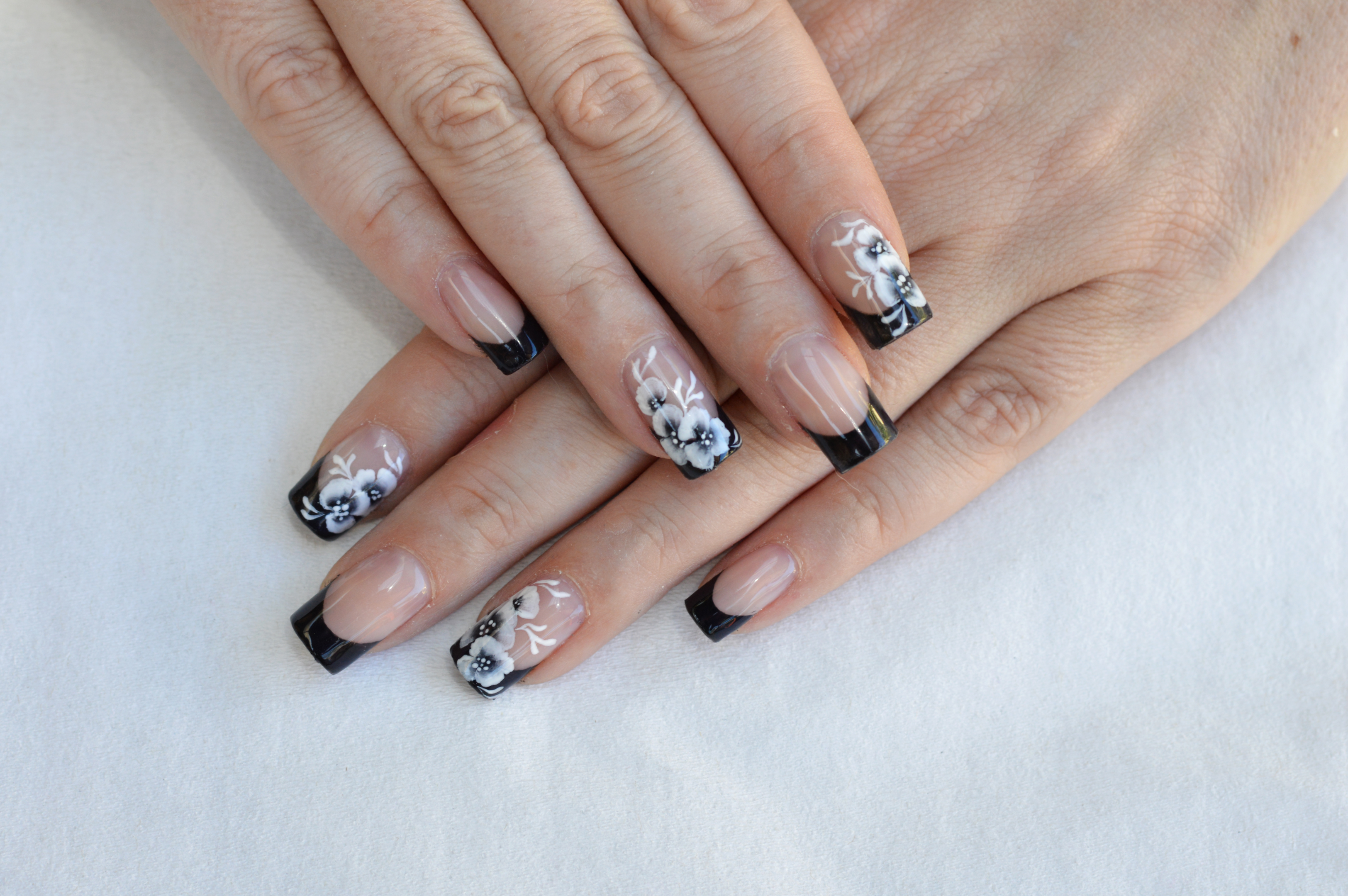 A black french tip manicure with a monochrome design