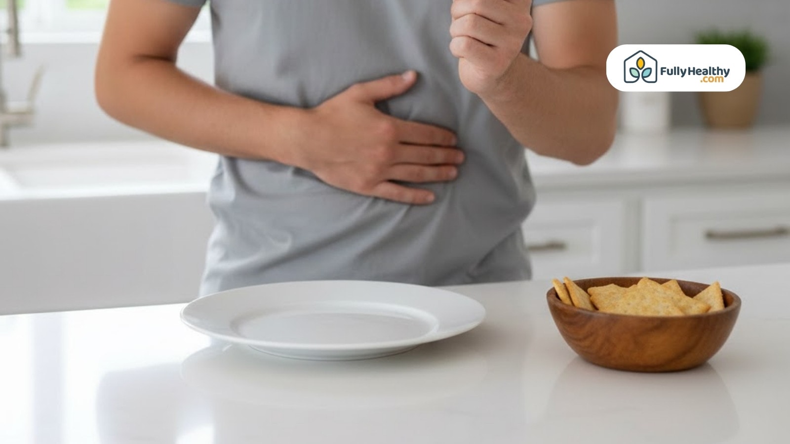 Man holding stomach beside empty plate and snack bowl