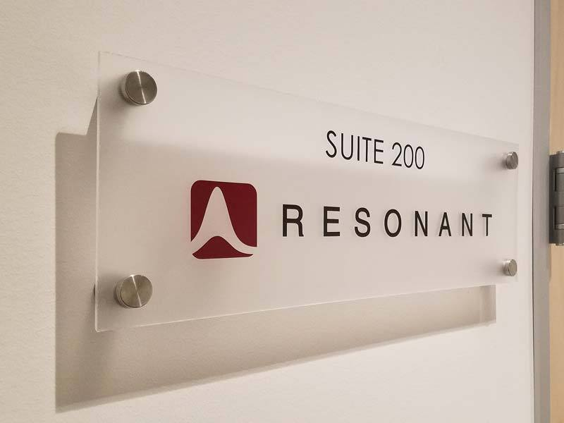Resonant business suite signs in Goleta, CA showcase the logo on an opaque finish with second surface printing.