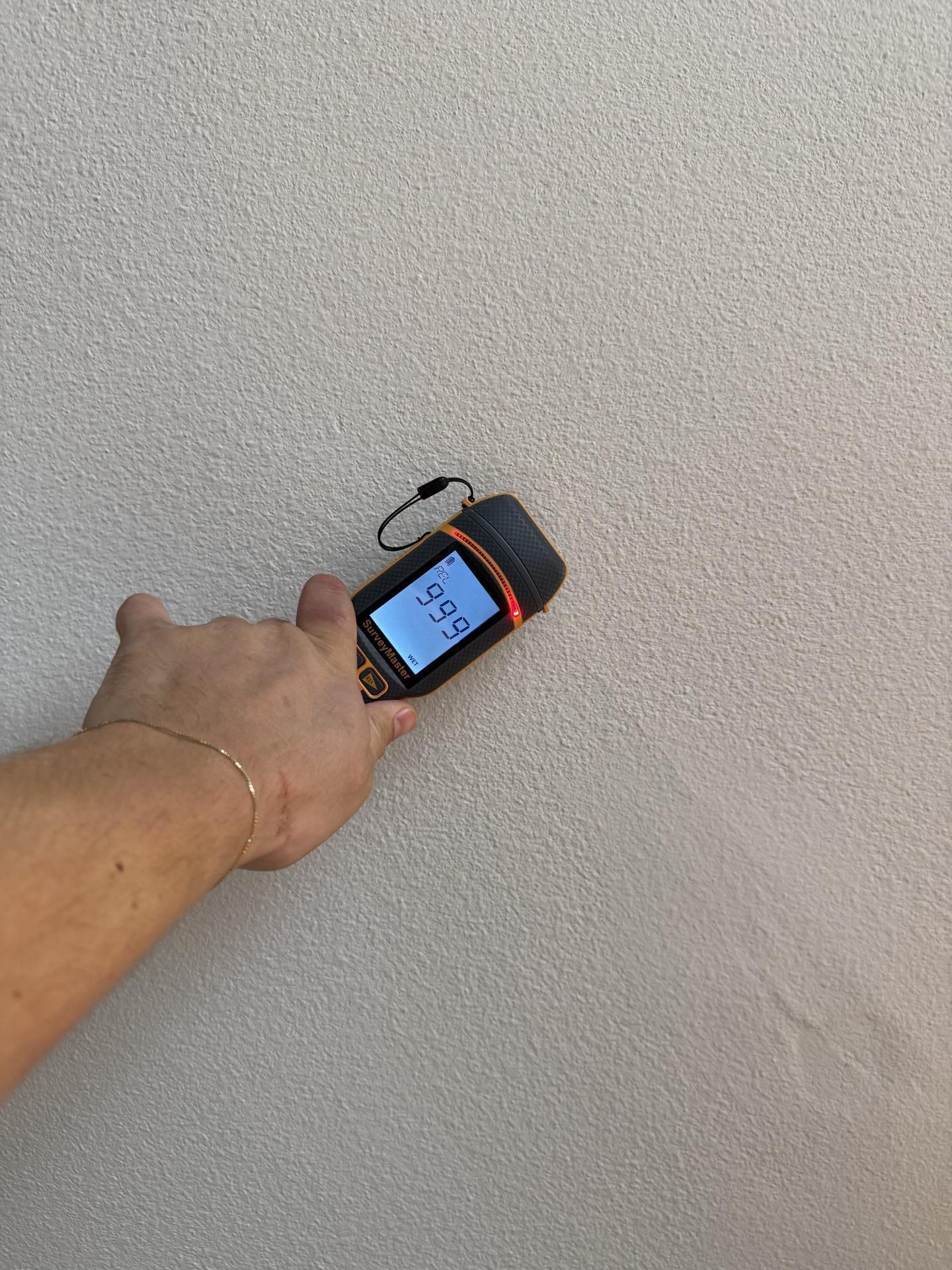 A restoration technician is using a moisture meter to assess a water-damaged wall, checking for excess moisture that could lead to mold growth and further damage. This essential step in the water damage restoration process helps identify affected areas and ensures proper drying and dehumidification.