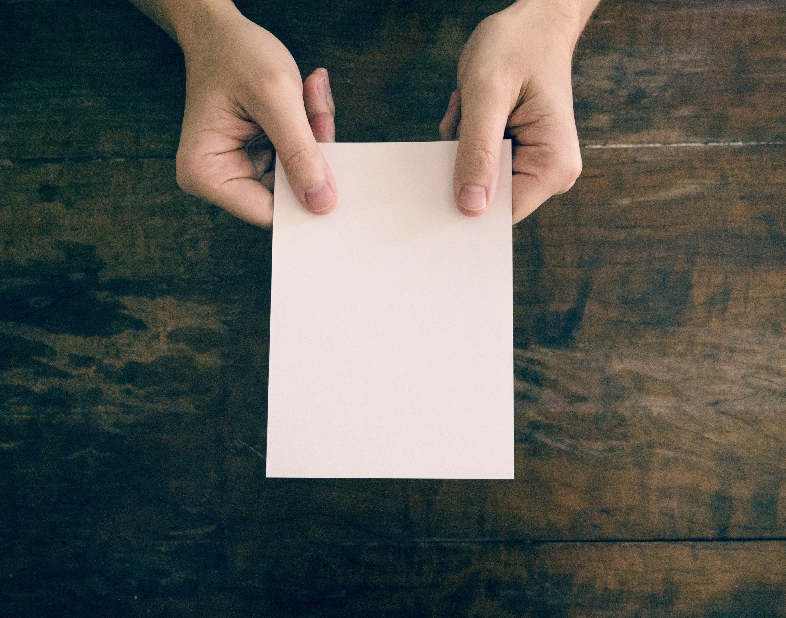 Blank postcard being held by real estate professional before it is written and sent as part of a mail campaign.