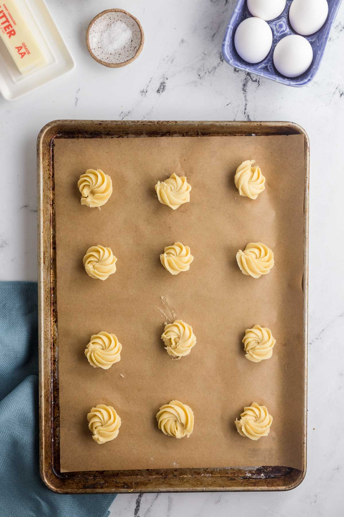 piped unbaked butter cookies on baking sheet