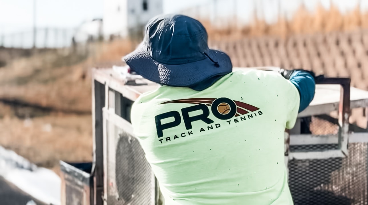 Crew member operating striping equipment during running track line marking phase.