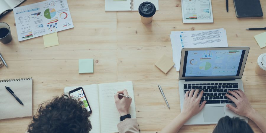 Top view of people in an office looking at graphs