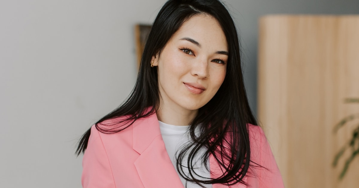 Young woman in a pink blazer smiling, representing professional CPA services.