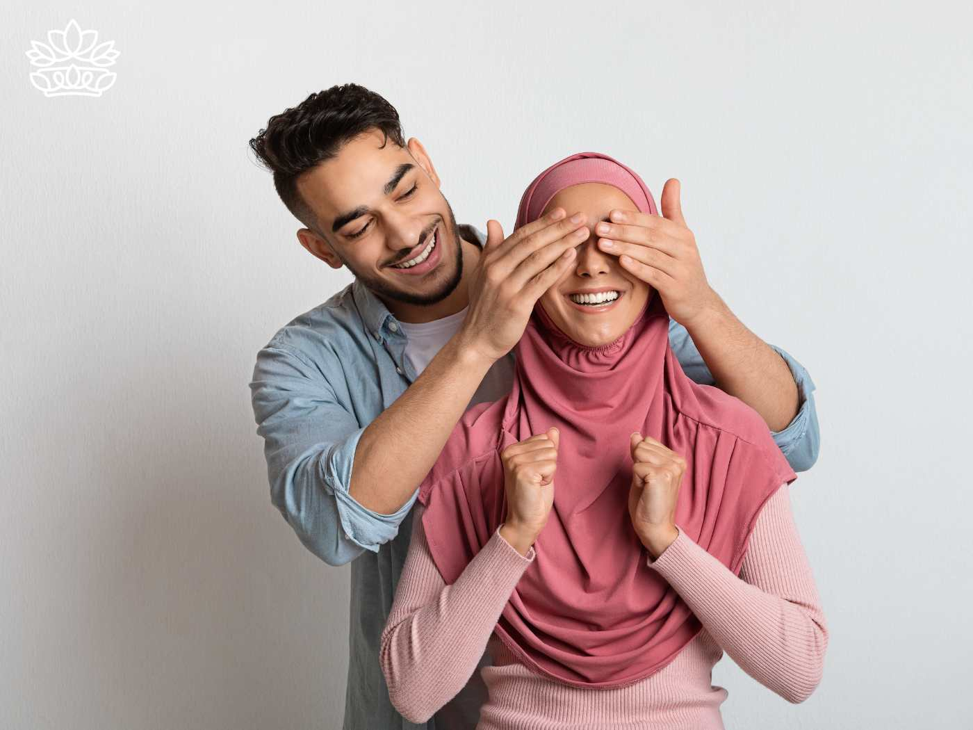 A man playfully covering his wife's eyes to surprise her, representing the Gift Boxes for Husband Collection - Fabulous Flowers and Gifts