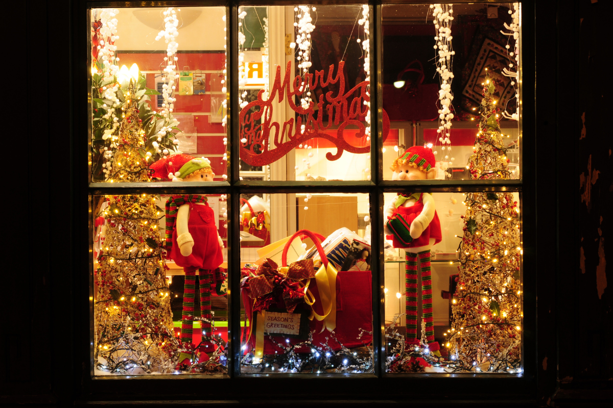 An illuminated window display showcasing vibrant Christmas decorations.