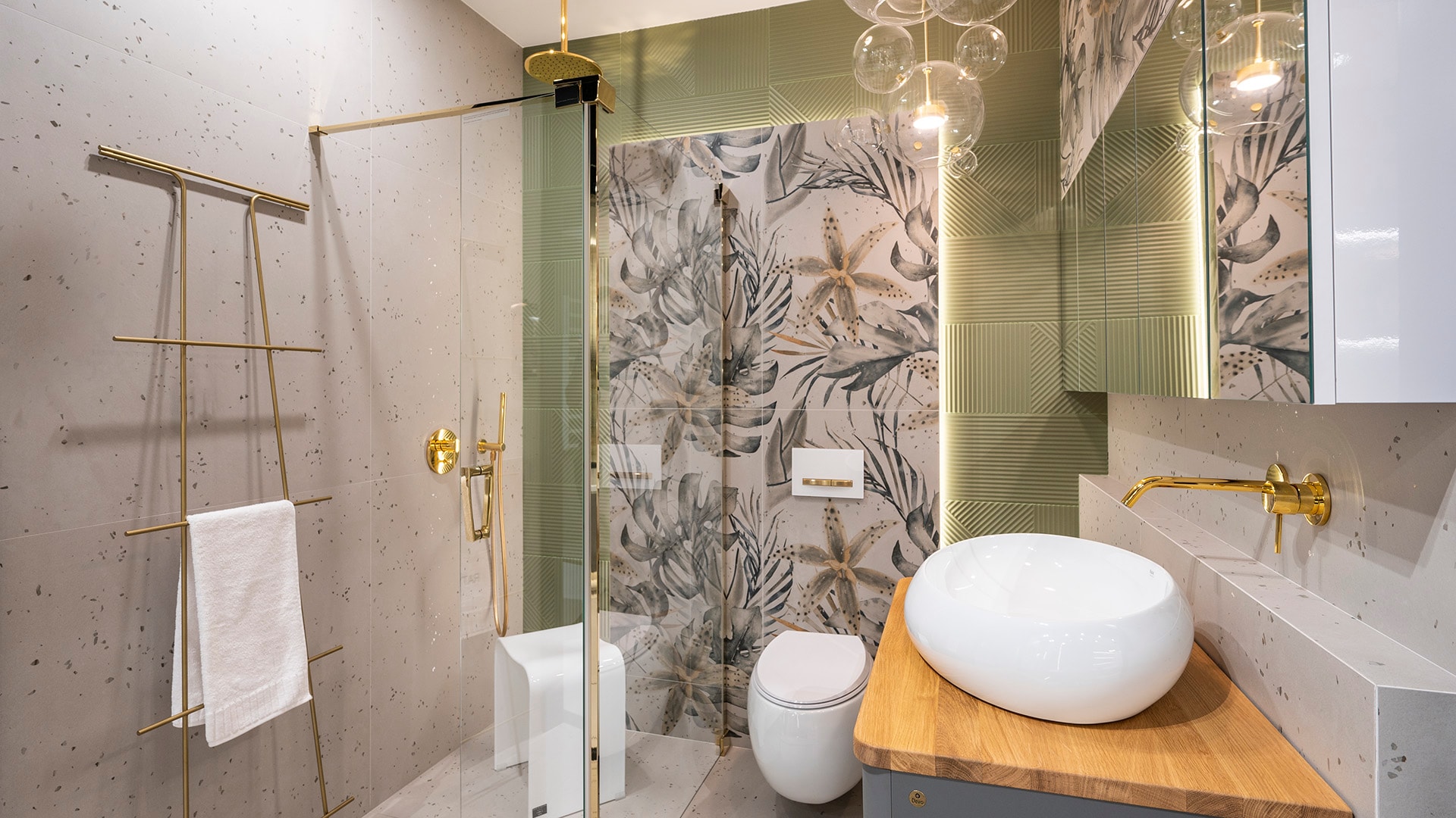 Zielona łazienka z motywem roślinnym i złotymi dodatkami