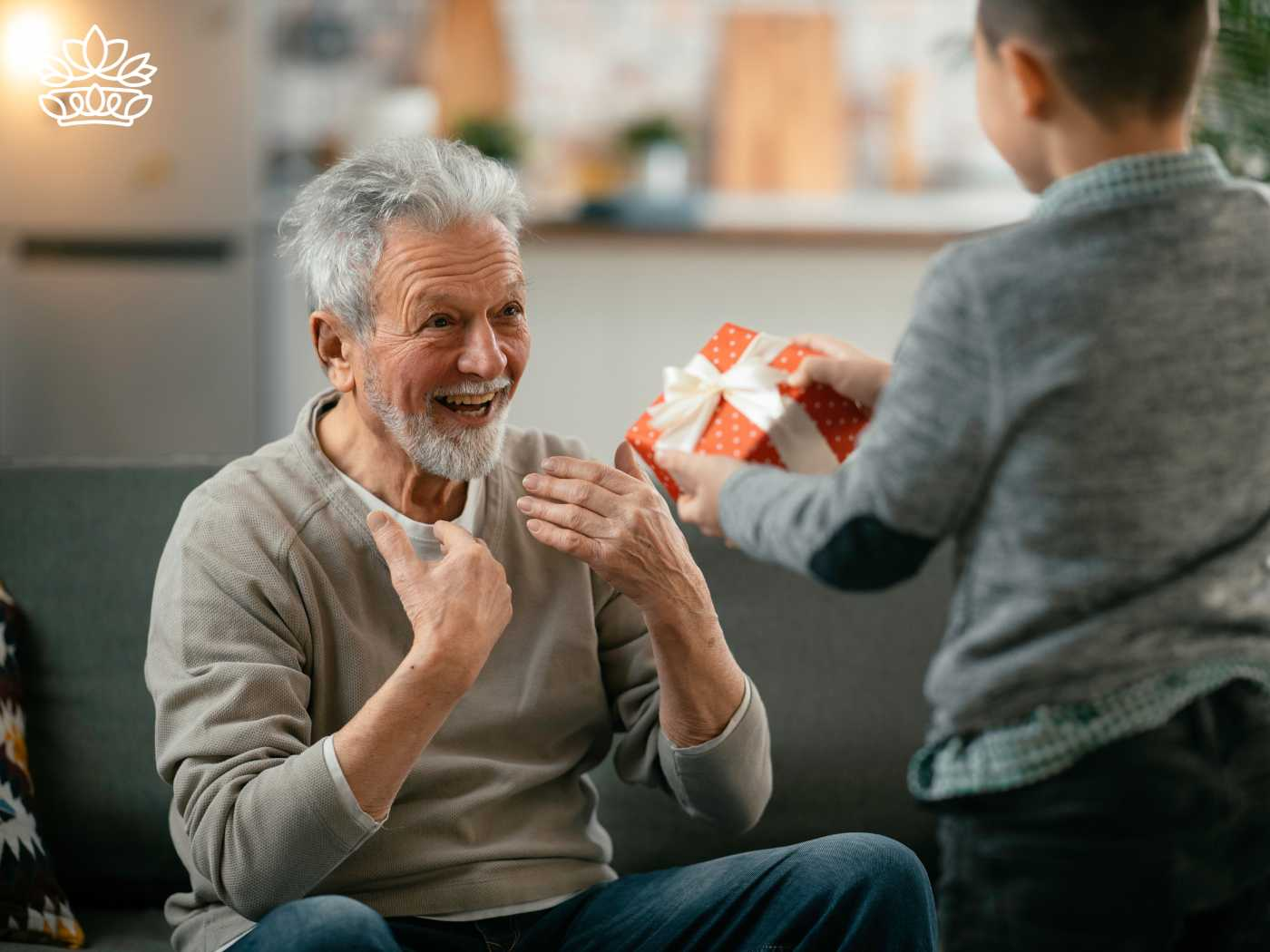 An excited elderly man receiving a wrapped gift from a young boy, from the Gifts Under R500 Collection at Fabulous Flowers and Gifts, including keywords such as brand, birthday, customers, and obsessed.