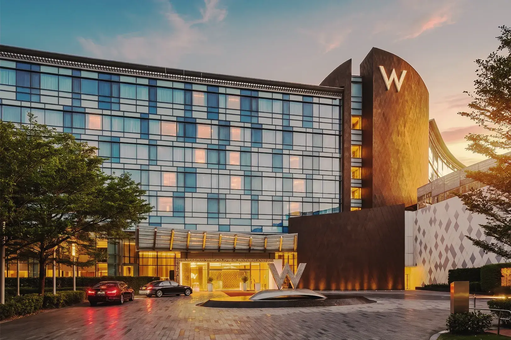 W Singapore hotel exterior showcasing contemporary architecture, illuminated entrance, and upscale hospitality experience at dusk