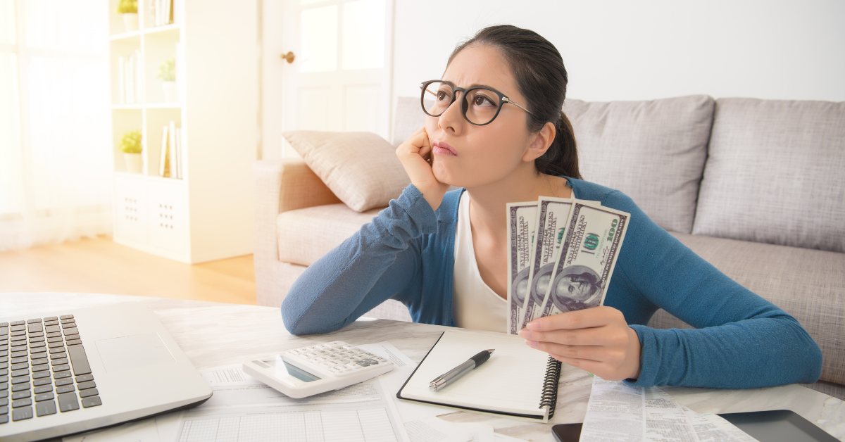 A woman organizing her finances using an income and expenses spreadsheet for OnlyFans.