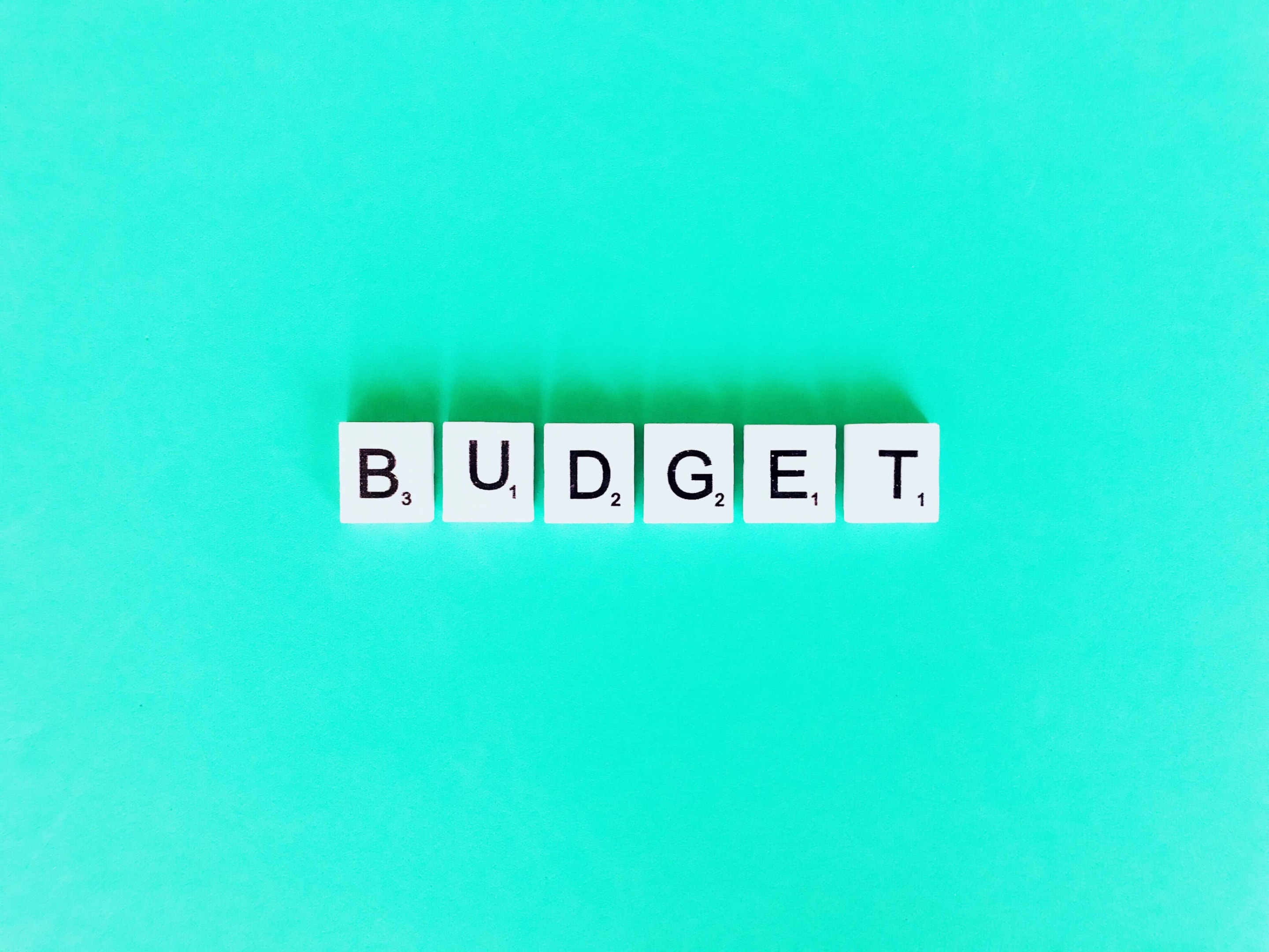 Scrabble tiles spelling “budget,” representing a basic survival budget for essential expenses.