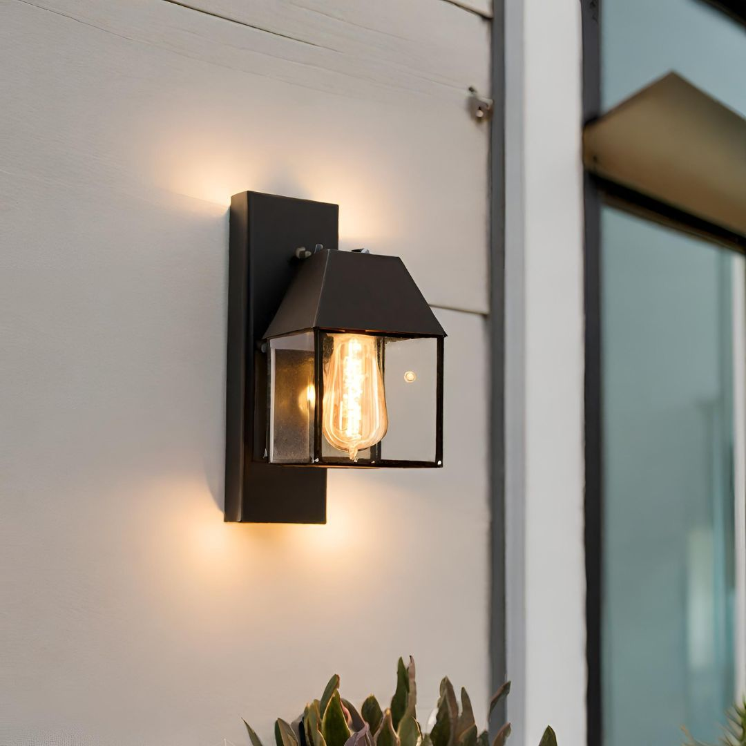 Retro design wall light with downturned light mounted to a wall on a house.