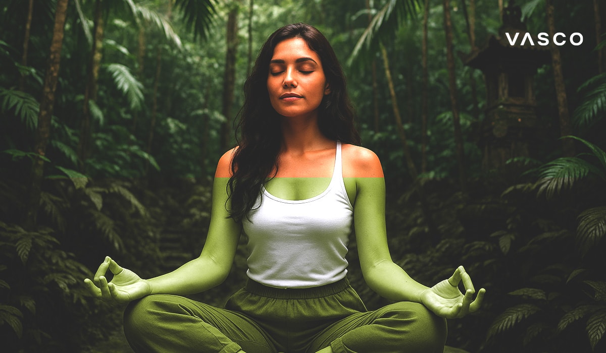 Una donna che medita pacificamente in posizione del loto, circondata dal rigoglioso verde di una foresta balinese.