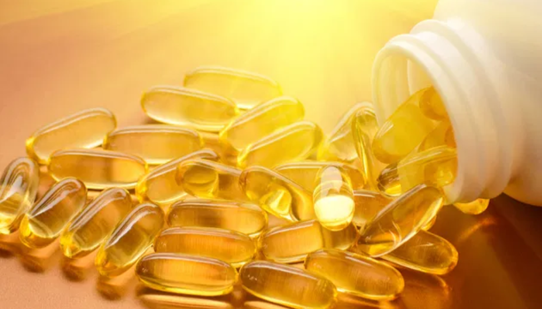 "Gule vitamin D-kapsler som renner ut av en hvit beholder, belyst av sollys i bakgrunnen, symboliserer kosttilskudd og helse."