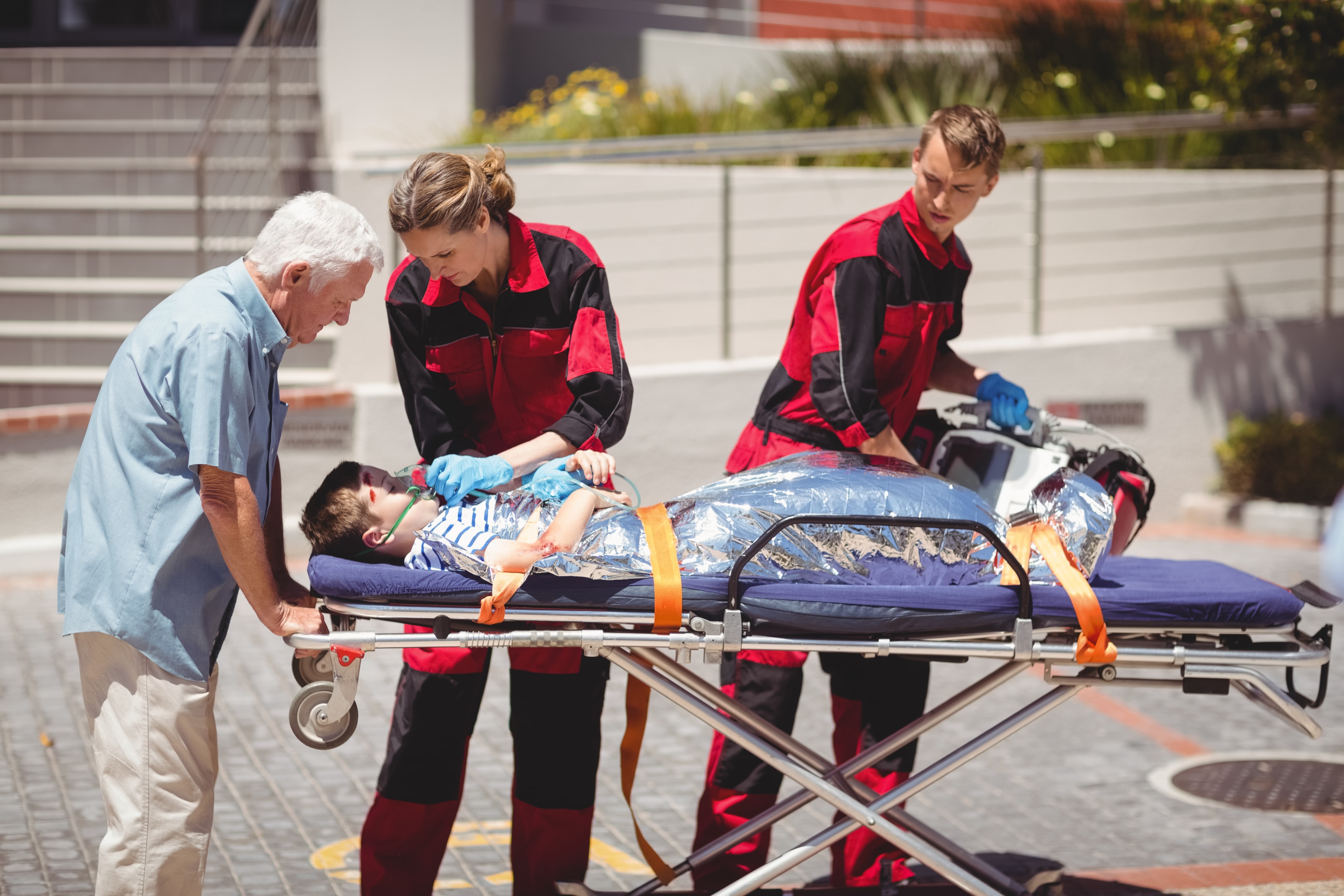 Paramedics attending to an injured boy on a stretcher (Designed by Freepik)
