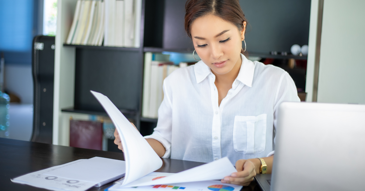 A woman completing tax paperwork at her desk, researching how to apply for an ITIN number.