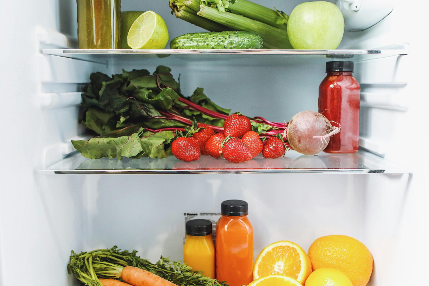 Fresh fruits and vegetables inside a refrigerator.