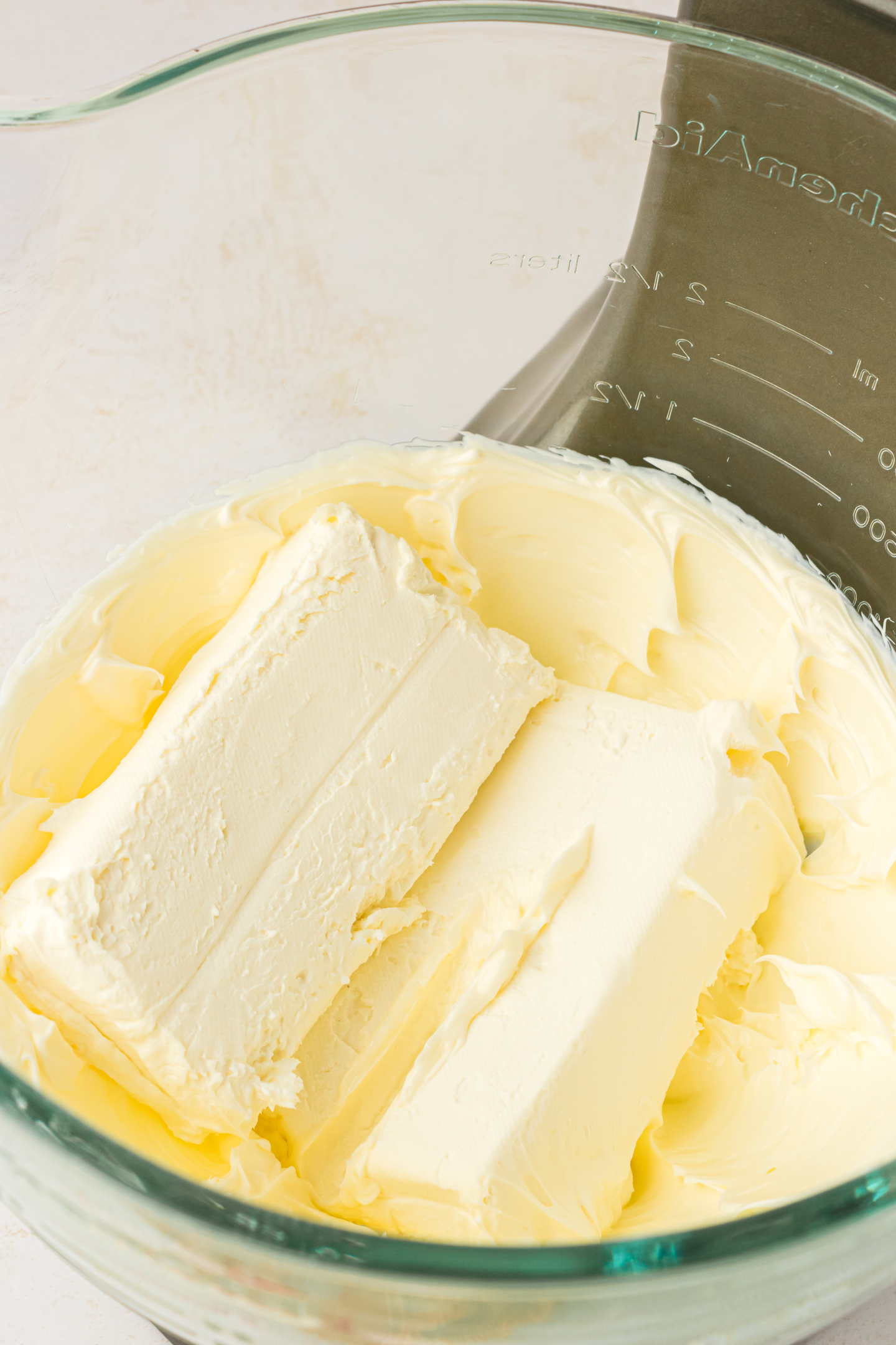 two blocks of cream cheese in a bowl with butter
