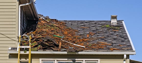  A picture of residential shingles being removed from a house.