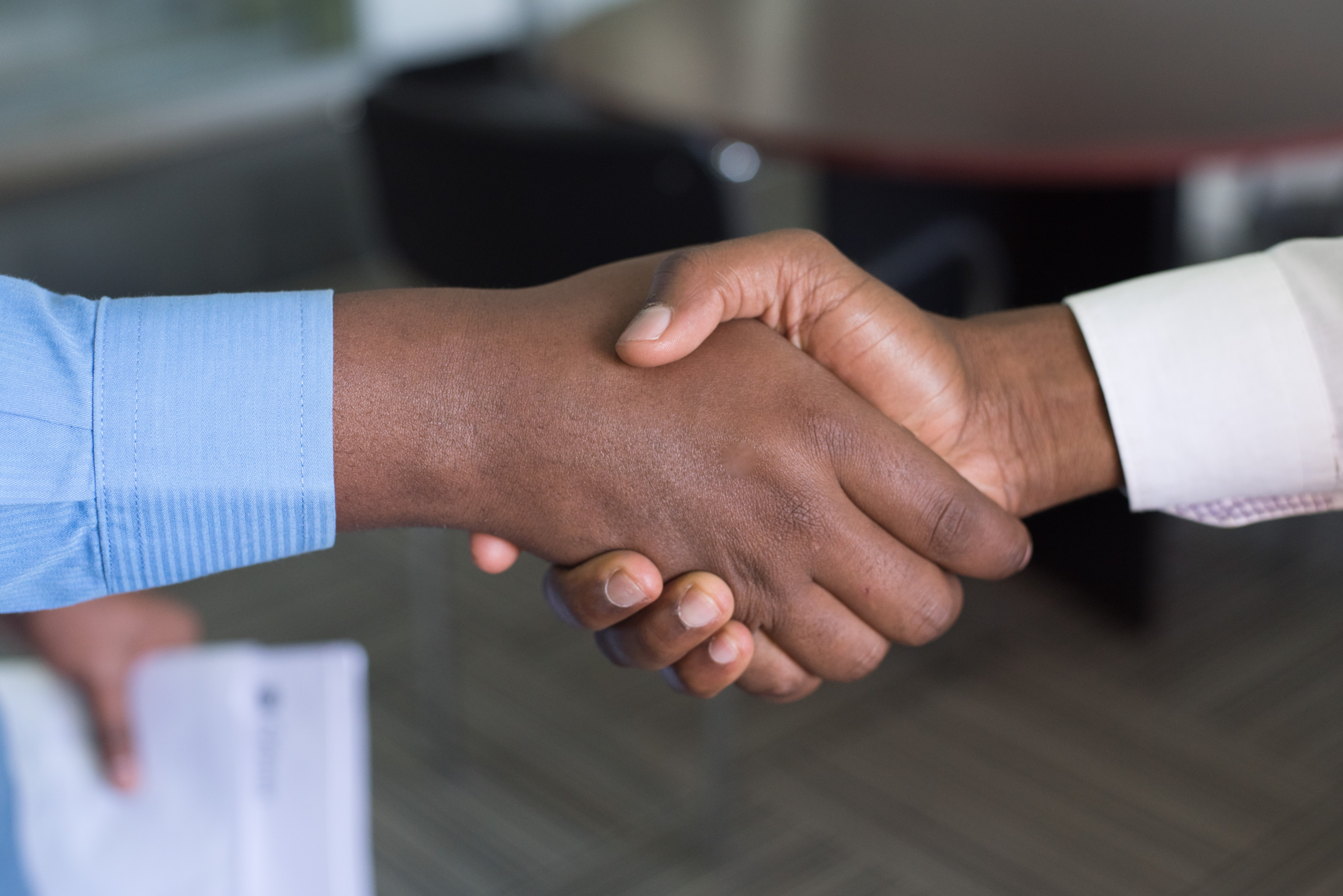 Photo of two person handshaking. 5 Actions to Take When You Get a New Client | Brittany Corporation