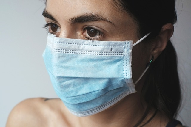An image of a woman wearing a surgical mask over her nose and mouth.