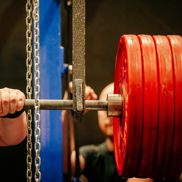 A photograph showing heavy weights loaded on a power rack barbell.