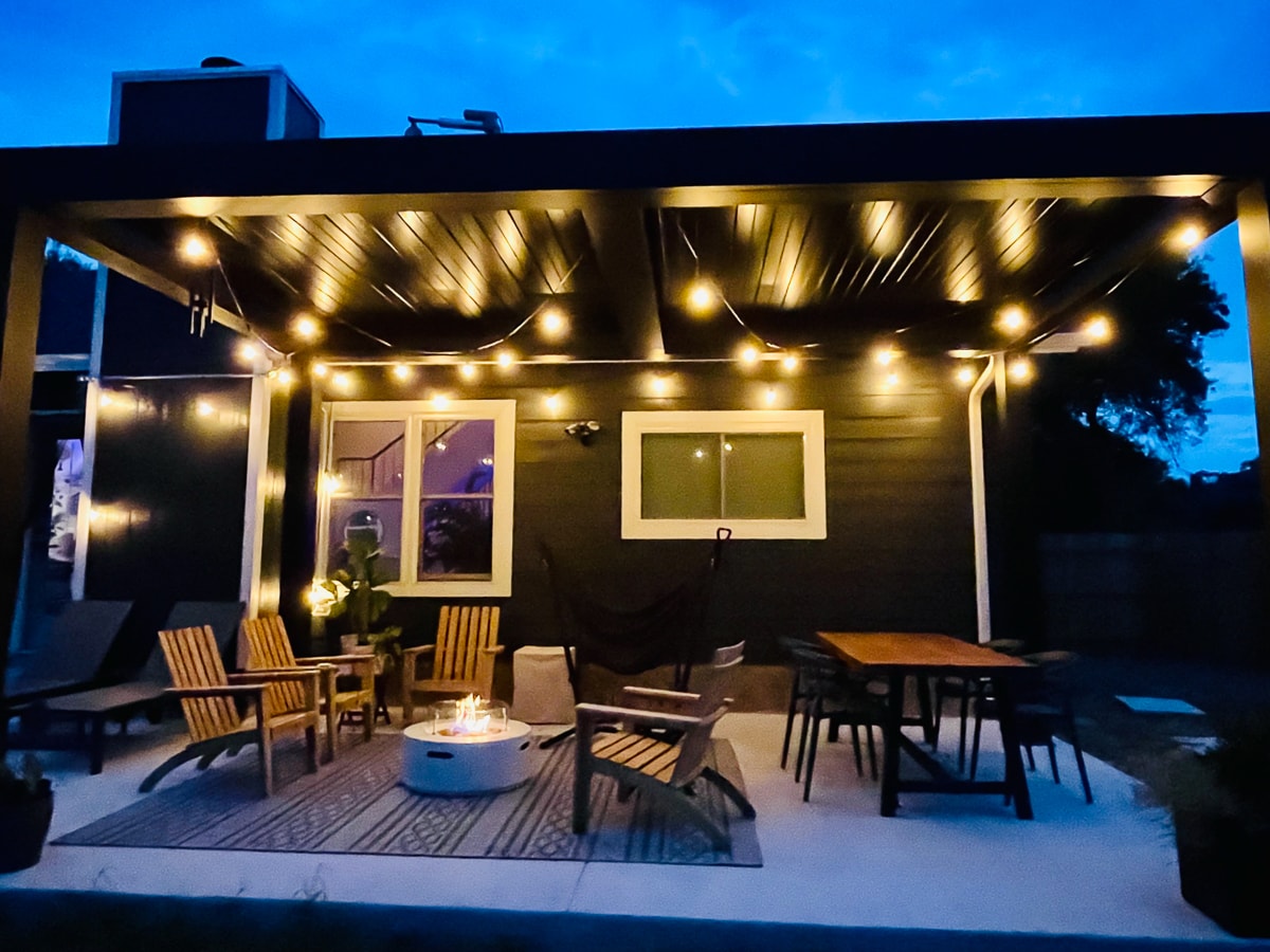 Whimsical aluminum pergola with string lights over a patio.