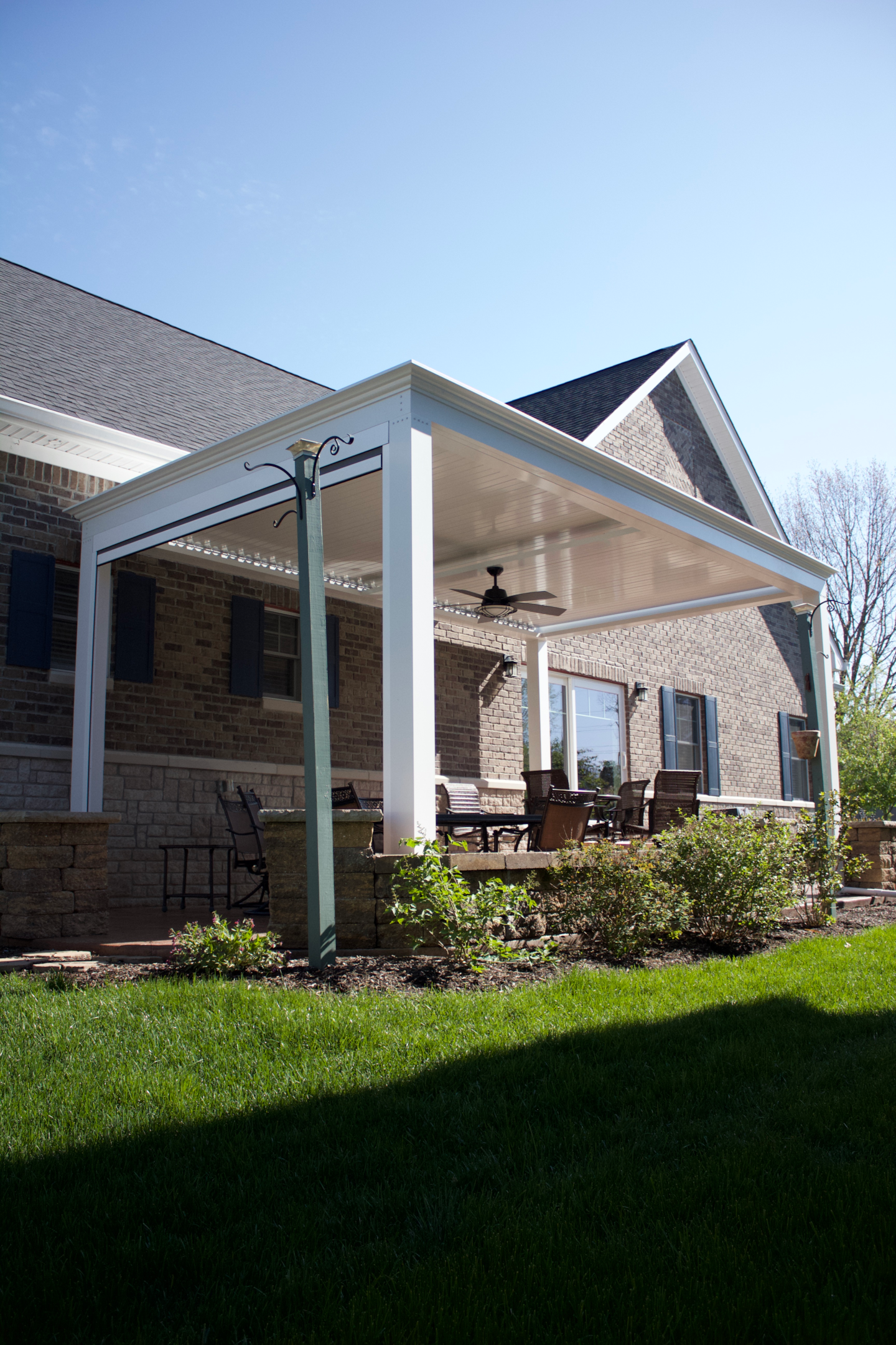 White pergola with louvered roof and furniture 