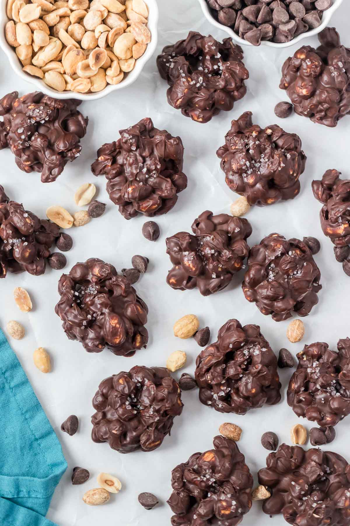 a bunch of chocolate peanut clusters on parchment paper