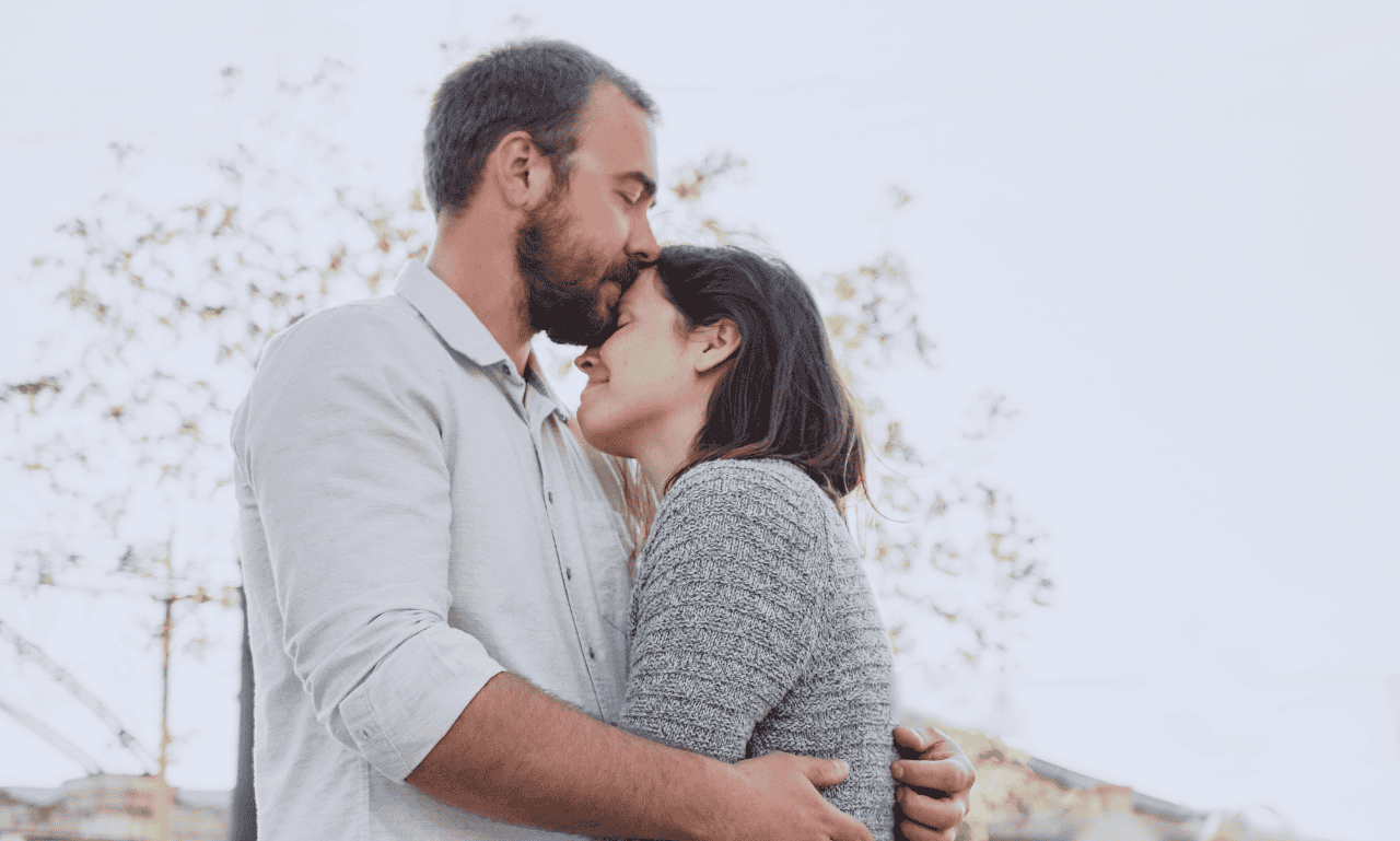 A couple having a goodnight kiss after the first date.