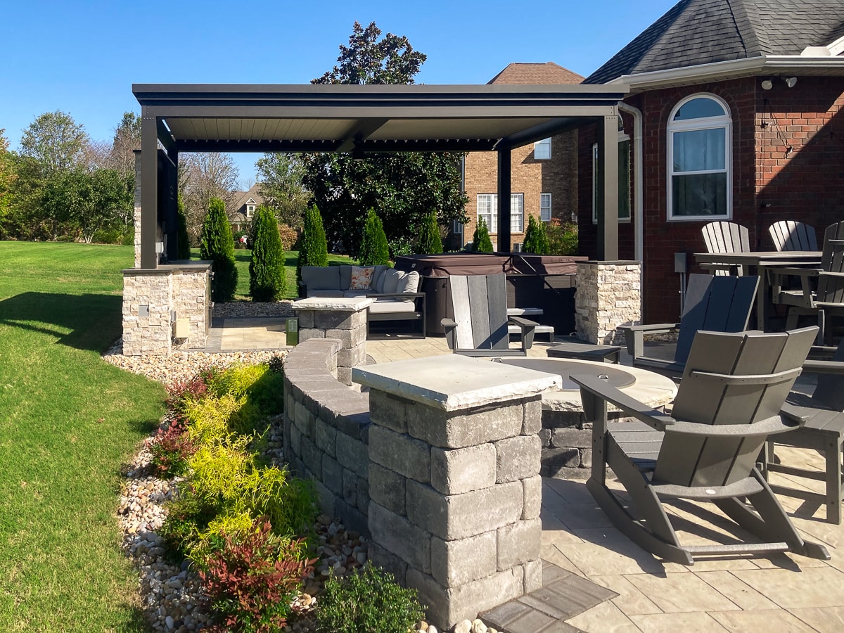 outdoor fireplace off away from pergola incorporated into the patio design.