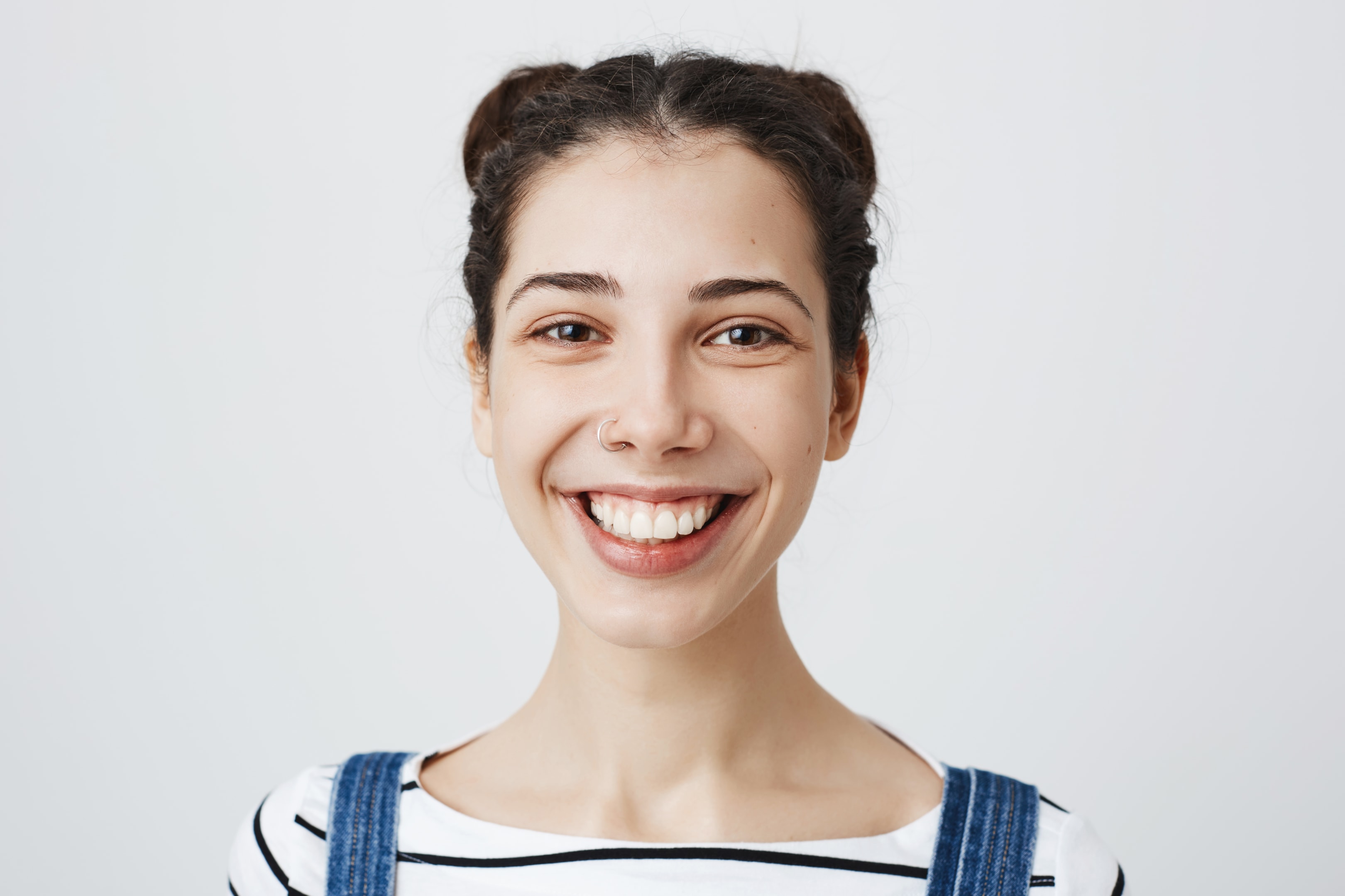 A woman smiling who has physical improvements after her chin surgery