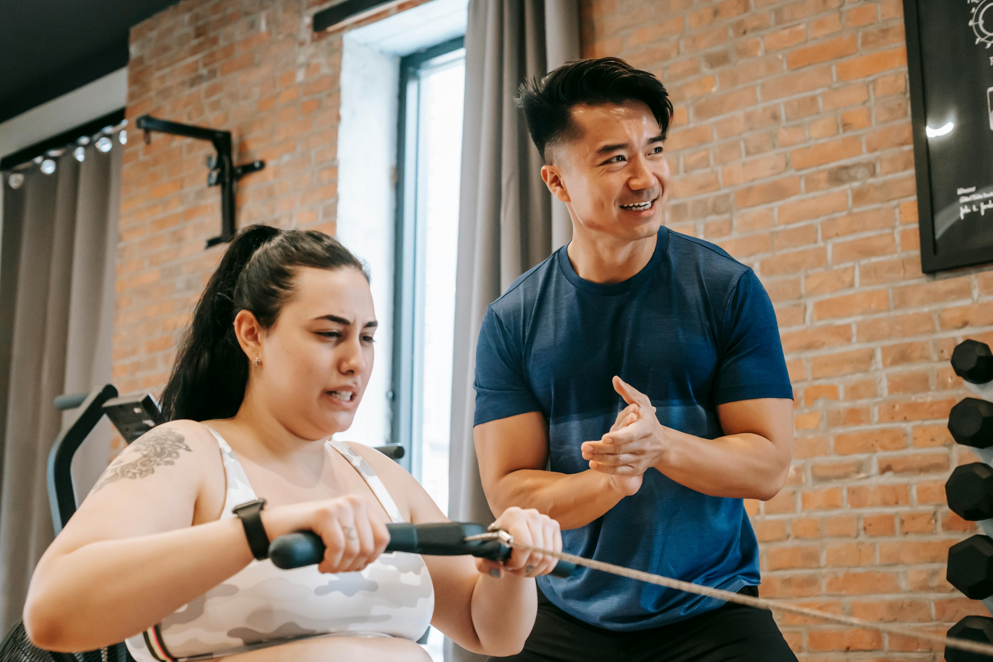 trainer helping a client on a rowing machine