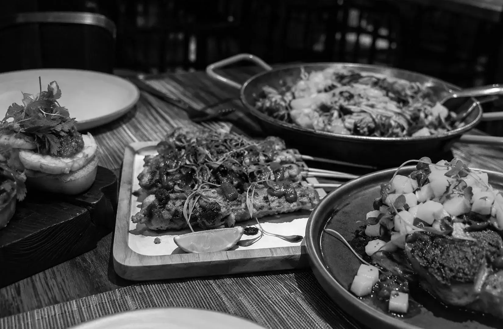 Assorted gourmet dishes including seafood and grilled specialties served for sharing.