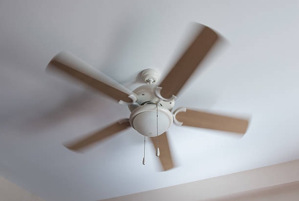 A ceiling fan rotating counterclockwise. 