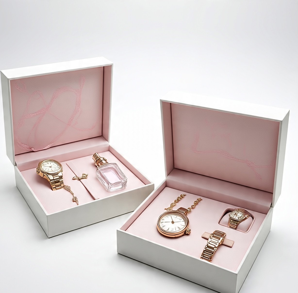 An image of two open gift boxes with pink interiors holding watches, jewelry, and a perfume bottle arranged inside.