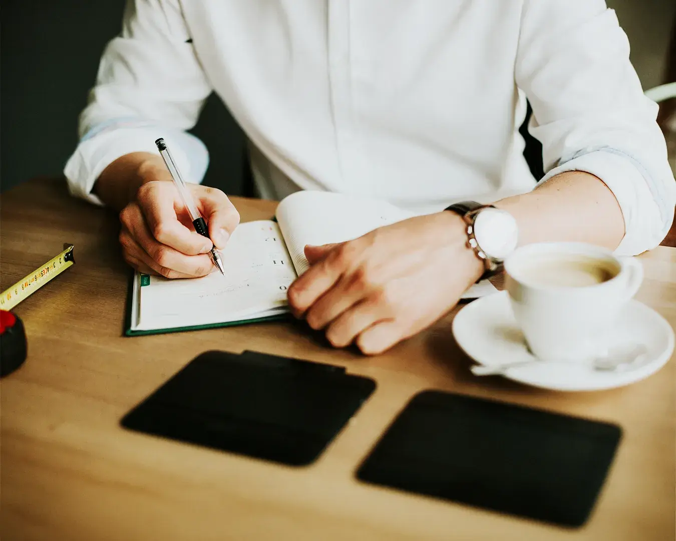 Restaurant owner reviewing marketing strategy and campaign budget notes with coffee and business planner