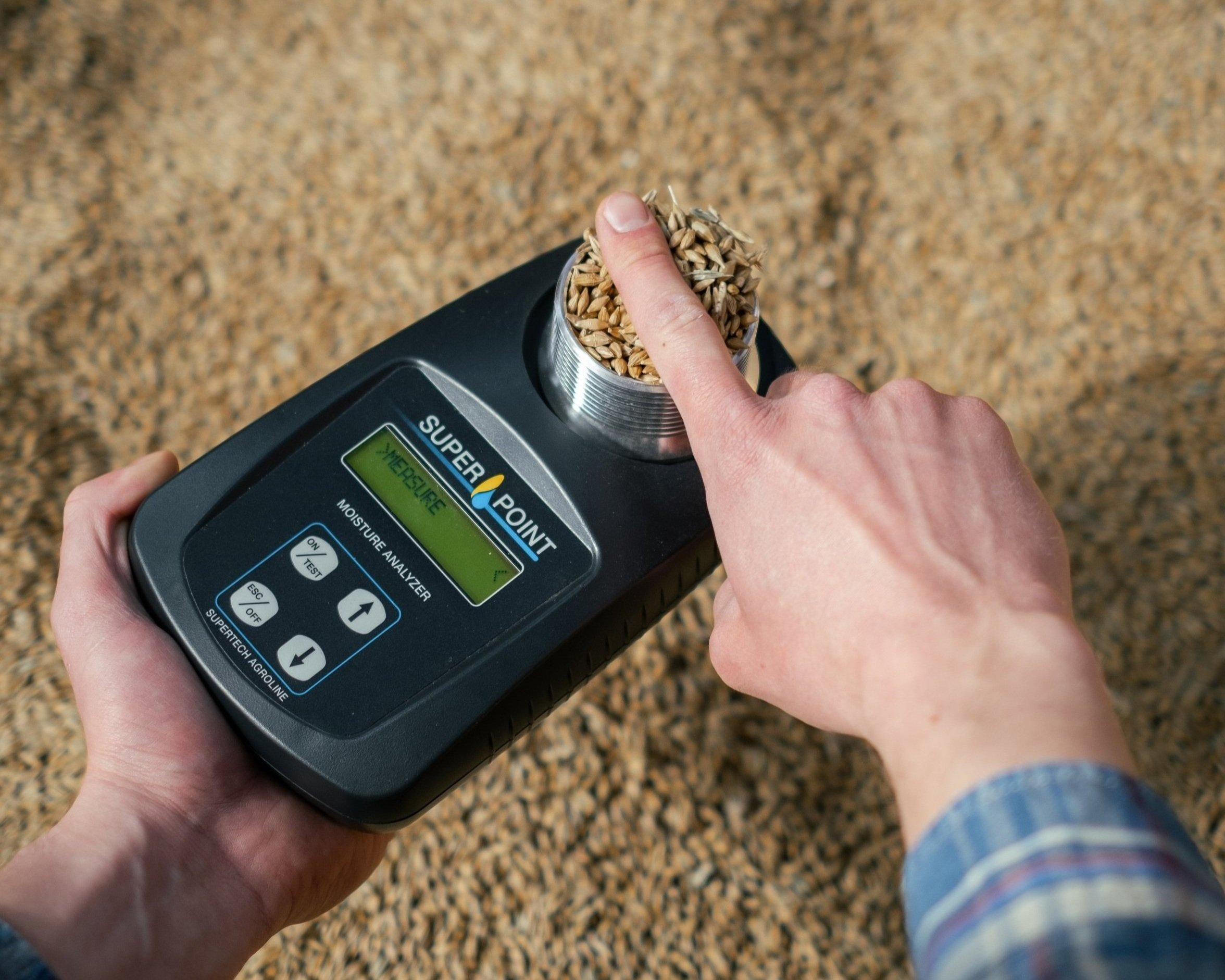 A person holding a grain moisture tester