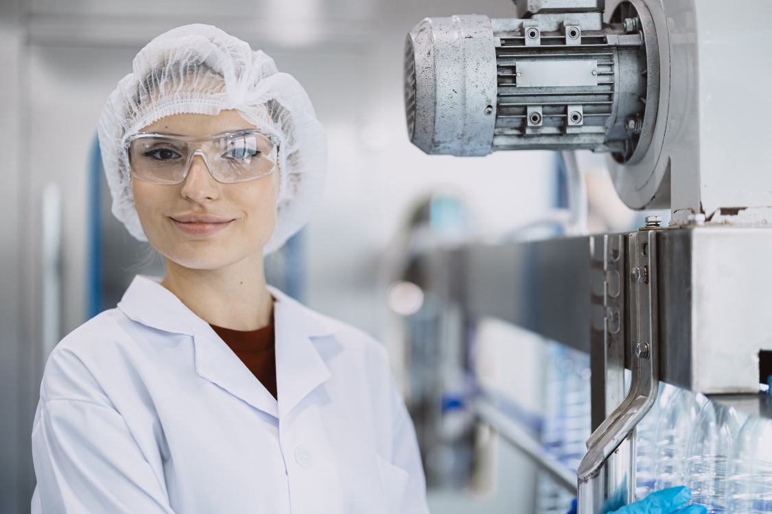 Lab technician in cleanroom uniform at a dietary supplement production facility
