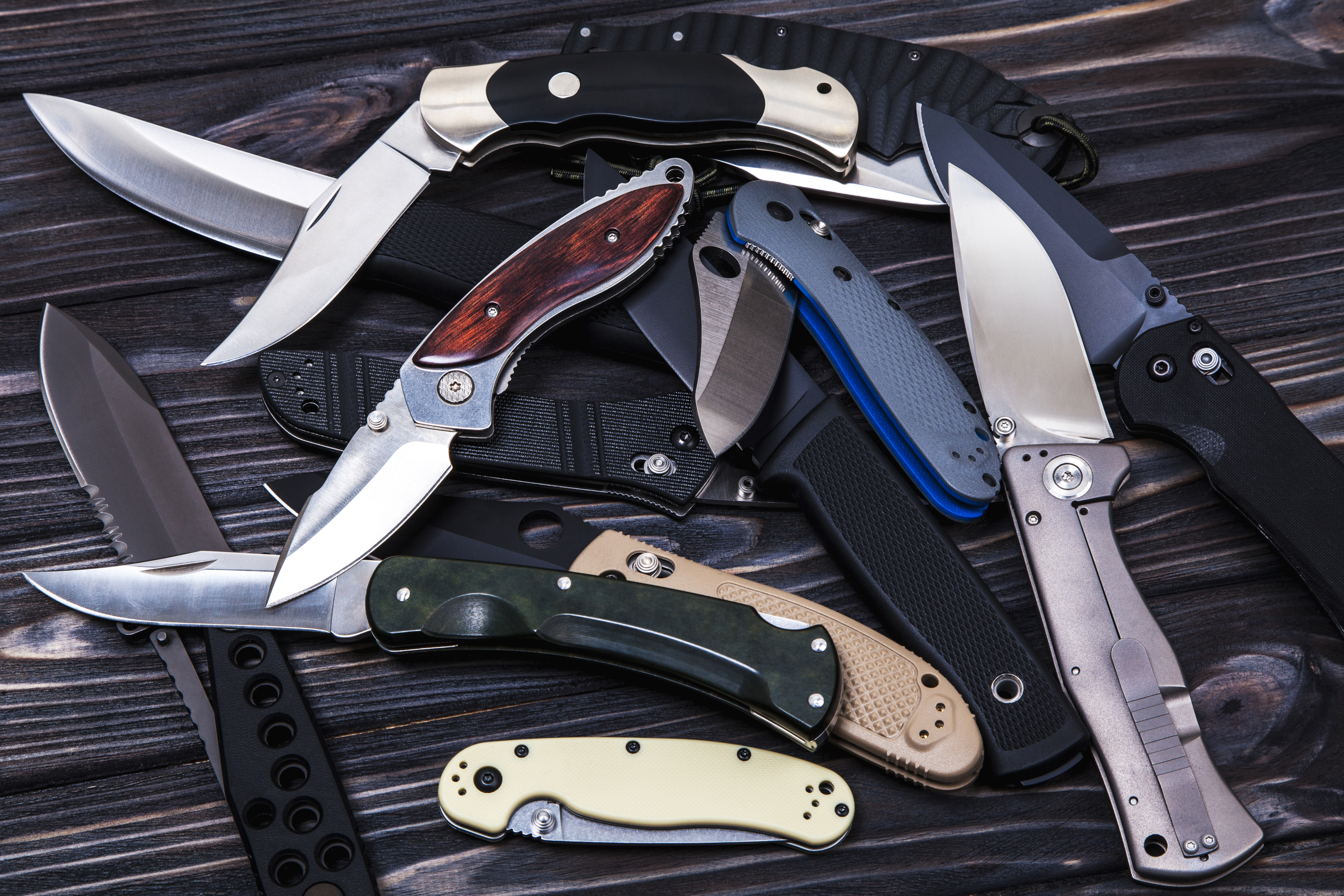 Folding knives on a wooden background