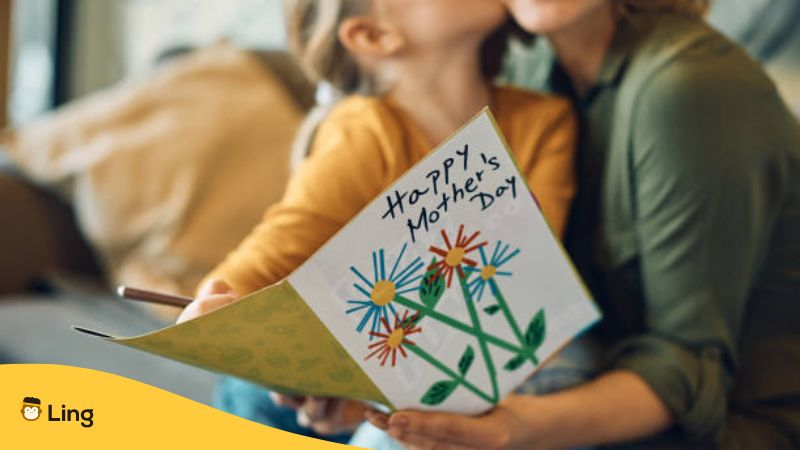 Happy mother's day card with a kid kissing her mother