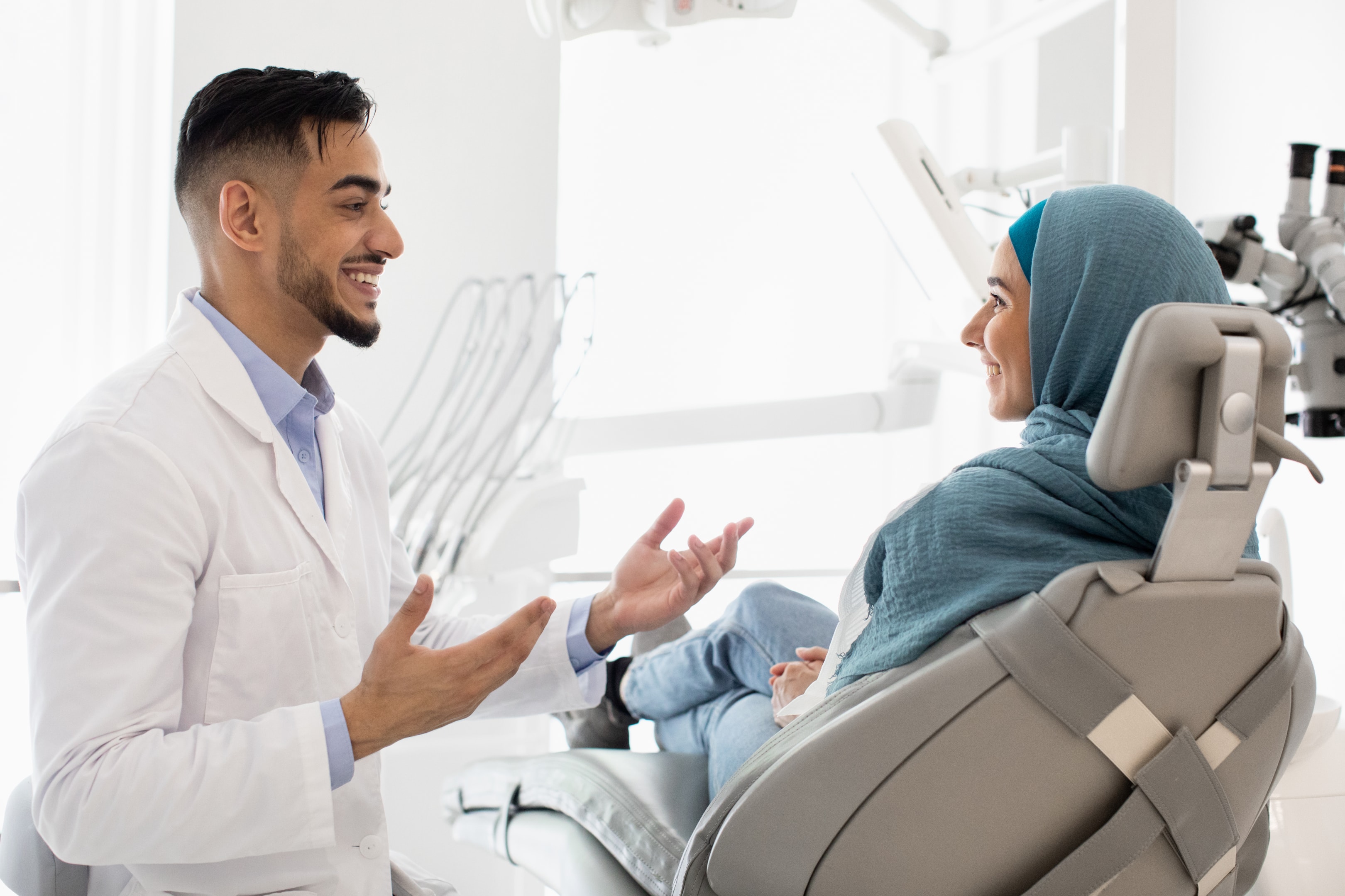 an oral surgeon speaking with a patient about her options for wisdom tooth extraction in the dental clinic