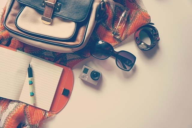 A bag, watch, camera, pen, and a notebook, representing being a travel writer.