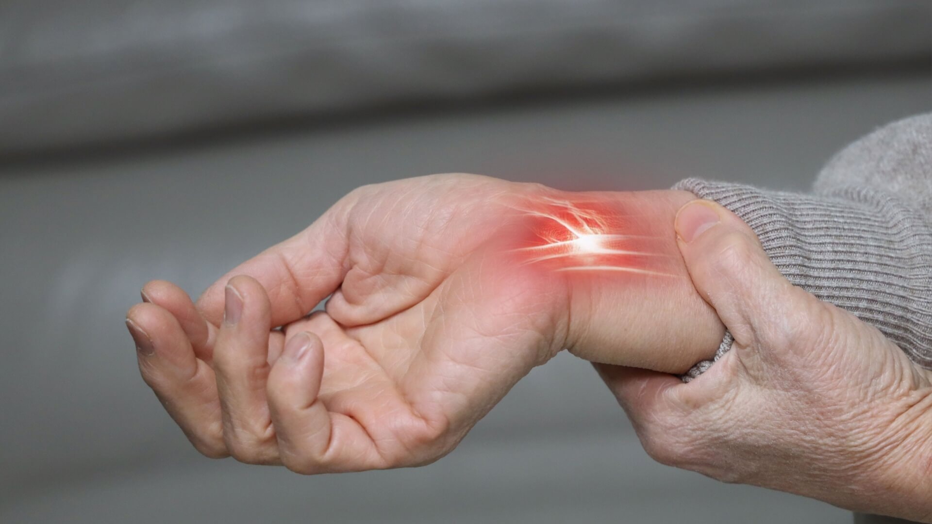 Mann med smerter i foten som kan tyde på nerveskade, sittende på sofa i hjemmemiljø og holder foten med begge hender.