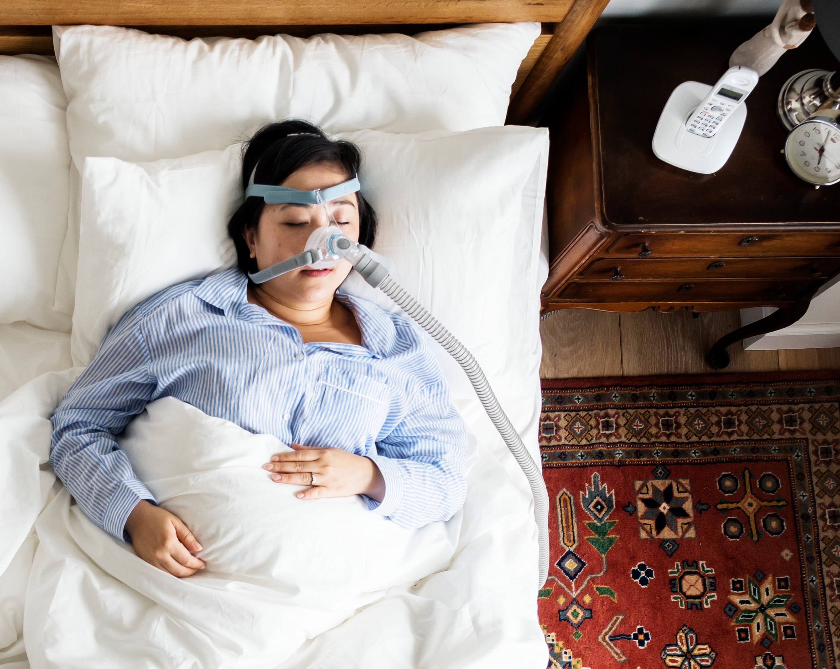 Woman sleeping with mask to help fix sleep apnea